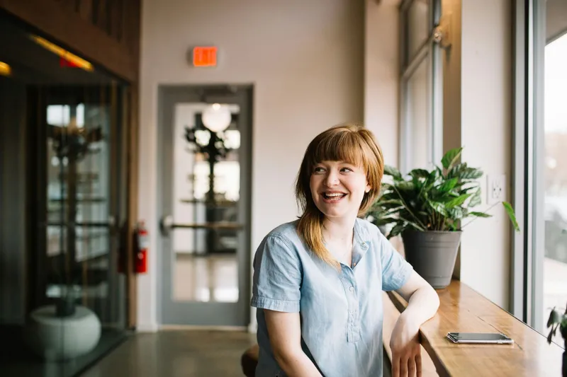 A smiling caseworker taking a break by a window